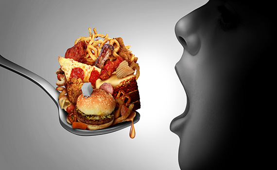 Uma criança a comer uma colherada de alimentos ultra-processados que podem provocar cancro do aparelho aerodigestivo. Uma criança a comer uma colherada de alimentos ultra-processados que podem provocar cancro do aparelho aerodigestivo.