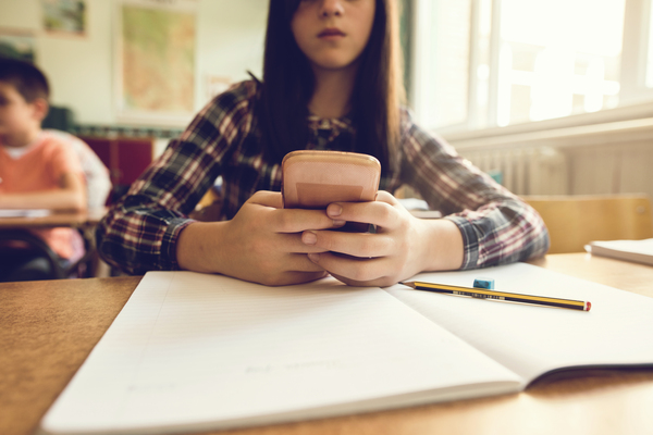 close-up-of-schoolgirl-using-mobile-phone-in-the-classroom-