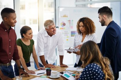 Ilustre o conceito de análise PESTEL mostrando seis pessoas numa reunião de negócios num escritório. Seis pessoas numa reunião num escritório.