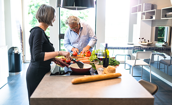 Um casal de idosos a preparar comida saudável. 