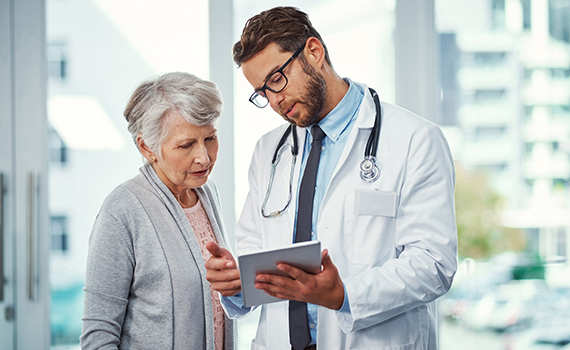 Um médico a explicar algo a um adulto idoso num ecrã. Um médico a explicar algo a um adulto idoso num ecrã.