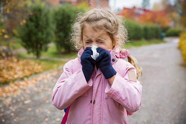 Uma menina constipada a assoar o nariz. A má qualidade do ar afectou as suas vias respiratórias. Uma menina constipada a assoar o nariz. A má qualidade do ar afectou as suas vias respiratórias.