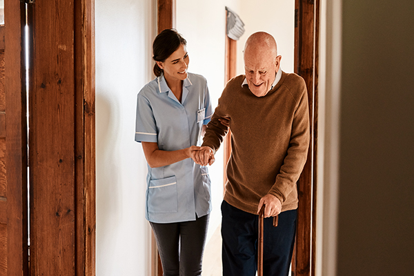 Assim, um idoso com dificuldades de locomoção é assistido por um enfermeiro.  