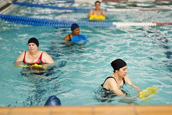 Mulheres a fazer aeróbica aquática numa piscina. Mulheres a fazer aeróbica aquática numa piscina.
