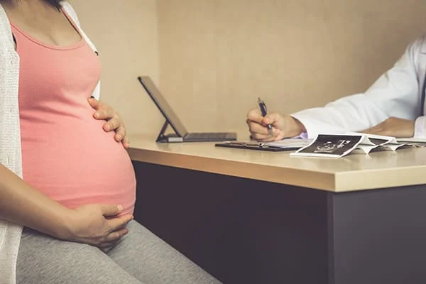 Uma mulher grávida a receber cuidados médicos.