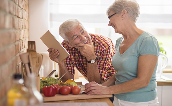 Un hombre mayor y una mujer mayor cocinando alimentos saludables para prolongar su vida. Un hombre mayor y una mujer mayor cocinando alimentos saludables para prolongar su vida.