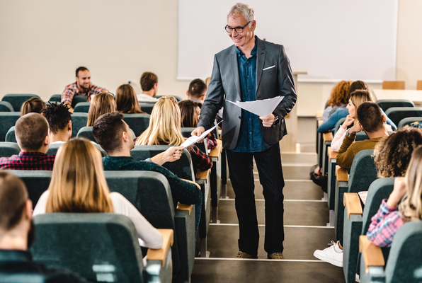 Ilustrar a un profesor sonriendo mientras recoge los exámenes en un aula de clase Profesor sonriendo mientras recoge los exámenes en un aula de clase