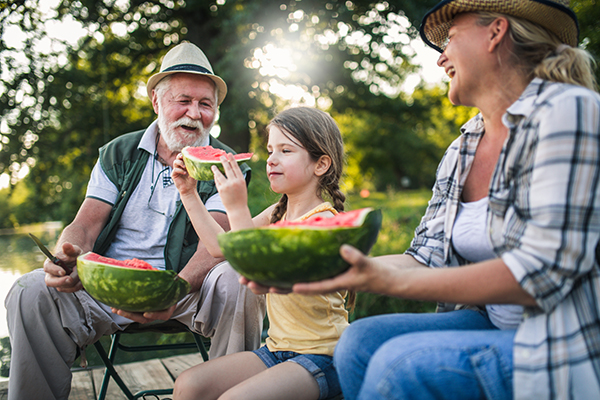 Una niña y sus abuelitos comiendo sandía para hidratarse adecuadamente. Una niña y sus abuelitos comiendo sandía para hidratarse adecuadamente.