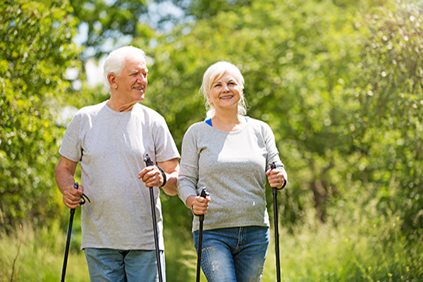 Dos adultos mayores realizando ejercicio de caminata en un parque natural. Dos adultos mayores realizando ejercicio de caminata en un parque natural.