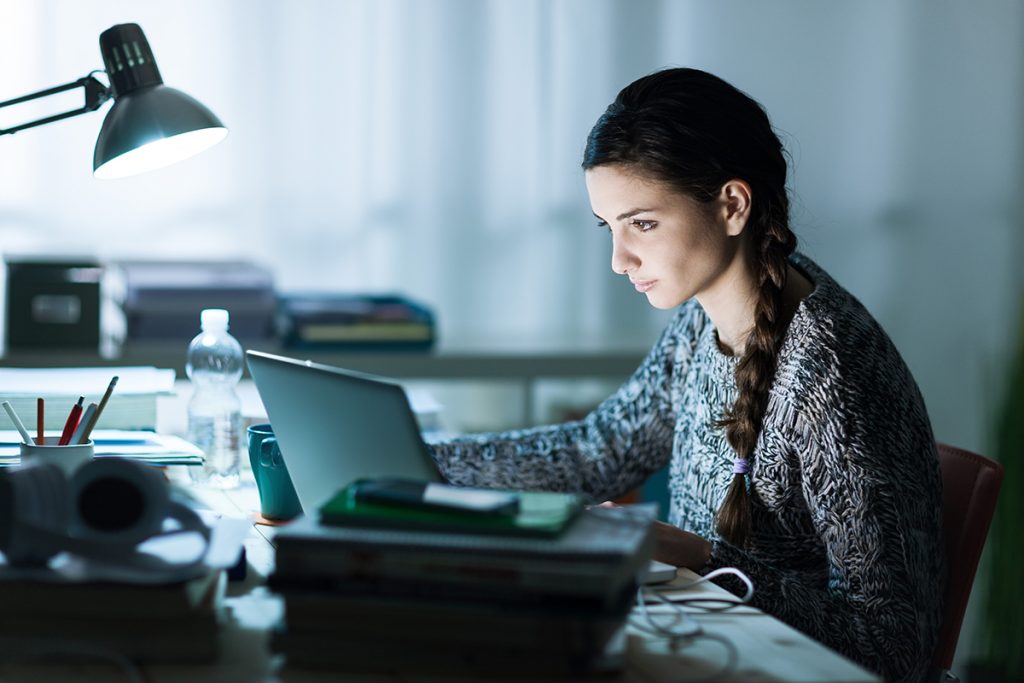 Mujer estudia en su computadora.