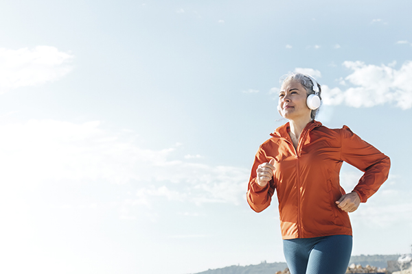 Una mujer adulta corriendo al aire libre para ralentizar el envejecimiento. Una mujer adulta corriendo al aire libre para ralentizar el envejecimiento.