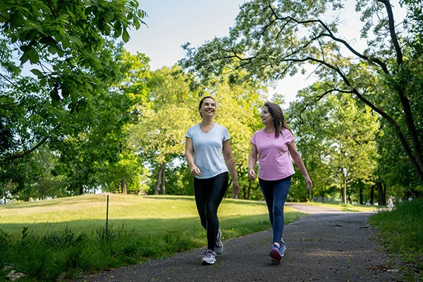 Dos mujeres adultas caminando 10 minutos al aire libre para controlar la glucosa. Dos mujeres adultas caminando 10 minutos al aire libre para controlar la glucosa.